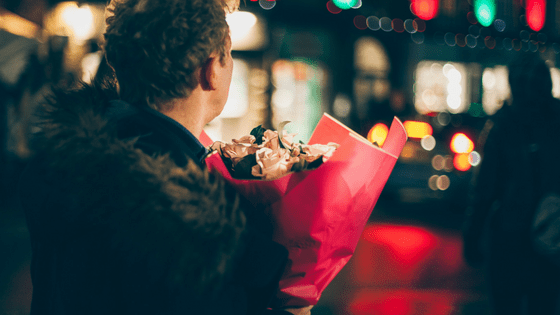 a man waiting for his date holding flowers