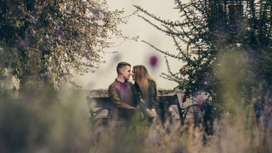 a couple sitting in a bench at the park